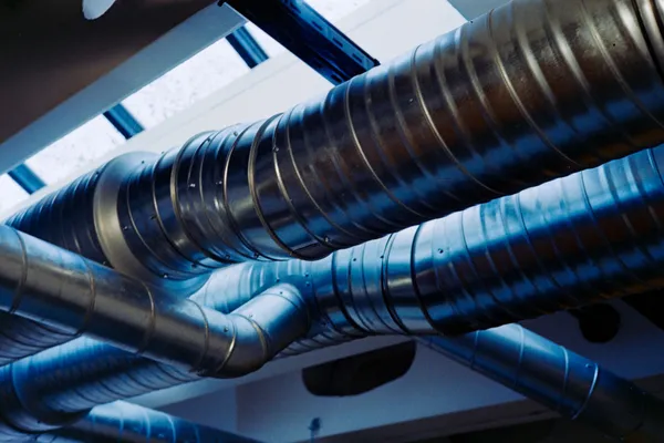 Large spiral ventilation ducts running beneath a structural ceiling